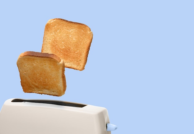 Toasted bread and toaster over light blue background Space for text