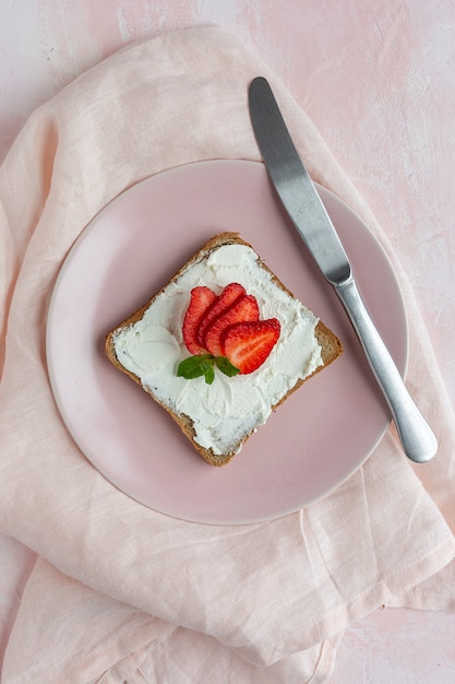 Toasted bread with fresh cheese and strawberries