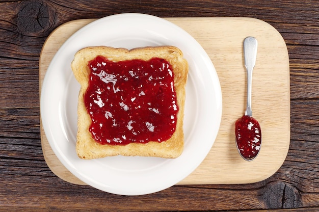 Toasted bread with jam on cutting board. Top view