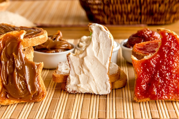 Toasted bread with jam, dulce de leche and ricotta cream on a breakfast table.