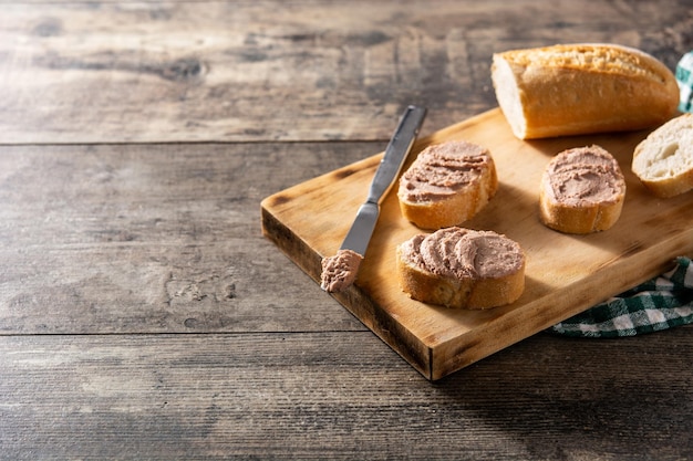 Toasted bread with pork liver pate on wooden table