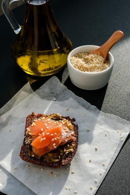 Foto pane tostato avocado e salmone. panini al guacamole. colazione salutare. olio d'oliva. semi di sesamo. alimentazione sana vegetariana.