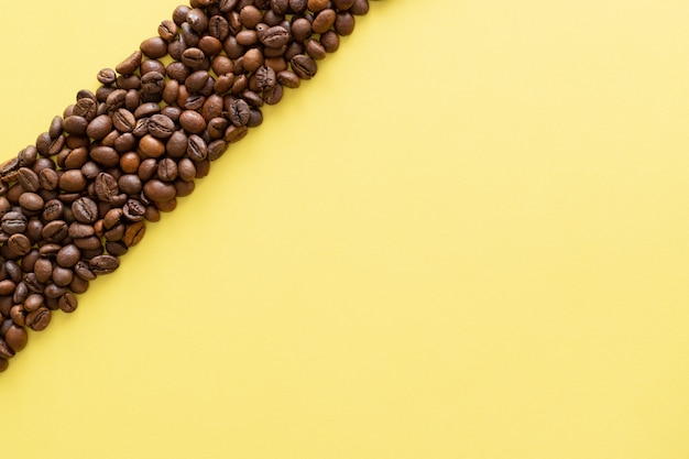 Toasted coffee beans on yellow background