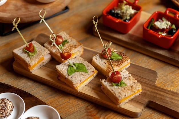 木の板にチーズのトーストサンドイッチケータリングと美しいテーブル