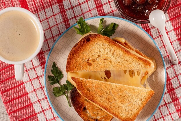 하얀 접시에 커피 한 잔에 치즈와 파슬리를 얹은 구운 빵 조각