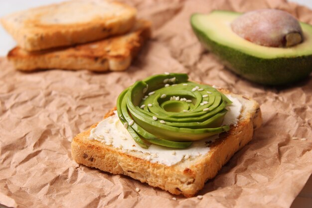 Toasted toast with avocado on a wooden table