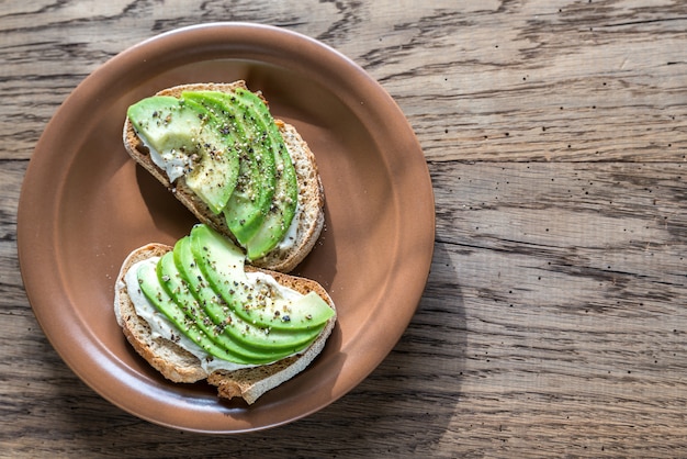 Toastjes met tahinisaus en in plakjes gesneden avocado