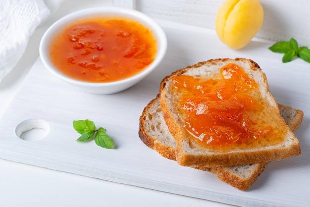 Toasts of bread with apricot jam and fresh fruits with mint