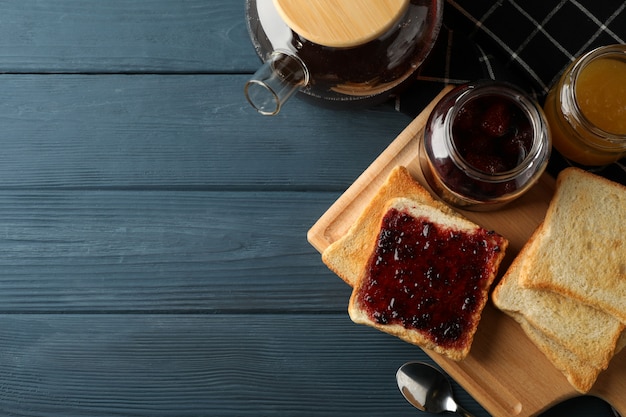 Toasts, jam and tea on wooden background, top view