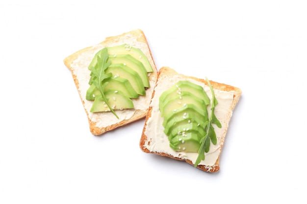 Toasts with butter, avocado, arugula and sesame isolated on white background