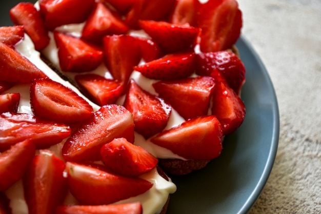 Toasts with cottage cheese and ripe strawberries on a plate