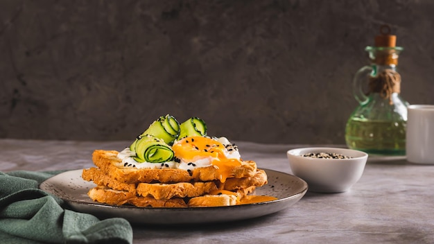 Toasts with cream cheese cucumber poached egg and sesame seeds on a plate web banner