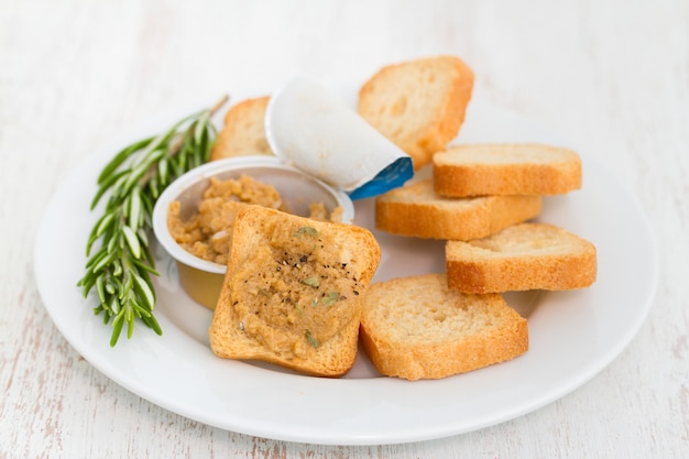 Foto pani tostati con patè di pesce sul piatto bianco