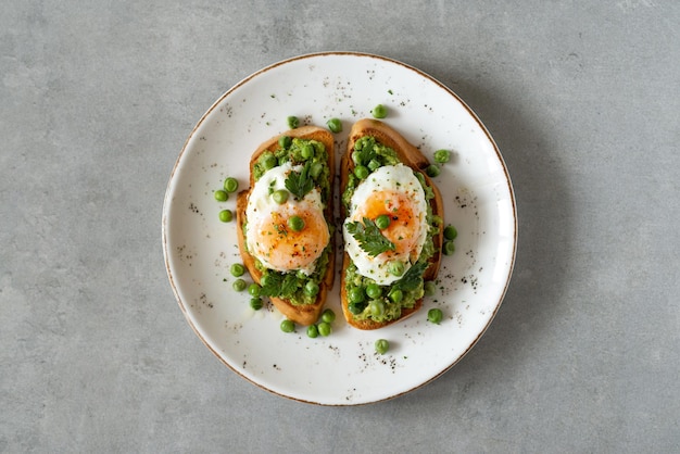 Toast con piselli e uova su uno sfondo di cemento pane tostato di piselli sani fatti in casa