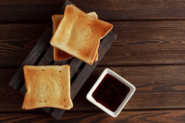 Toasts with jam on dark wooden table