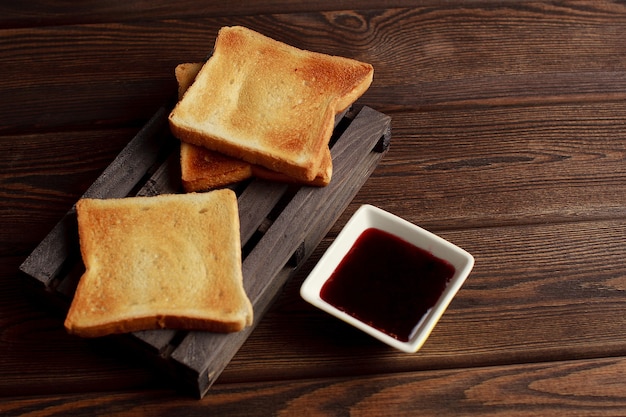 Toasts with jam on dark wooden table