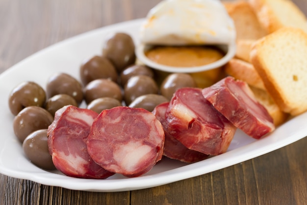 Toasts with smoked sausages, pate and olives