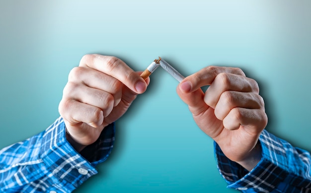 Il concetto di dipendenza da tabacco, smettere e smettere di fumare nicotina, frenare a mano una sigaretta isolata