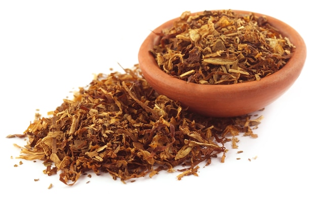 Tobacco for making cigarette on a small bowl over white background