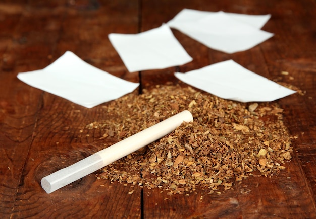 Tobacco and rolling paper on wooden background