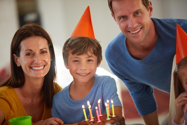 今日は私たちの息子の特別な日です家で誕生日パーティーをしている幸せな家族の肖像画