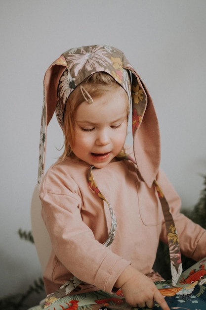 Photo toddler baby girl in funny hat with ears having fun