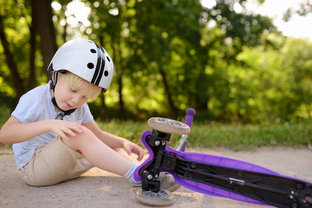 スクーターに乗ることを学ぶ安全ヘルメットの幼児男の子