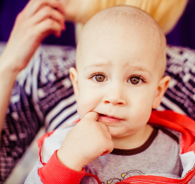 "Toddler boy putting finger in mouth"