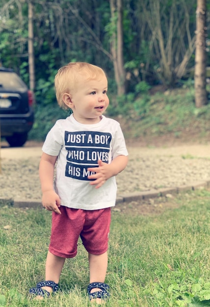 Photo toddler boy standing outside