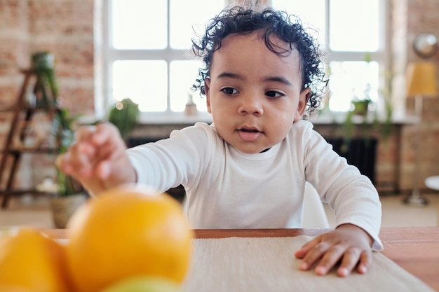 Toddler boy taking orange