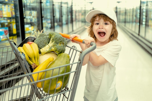 Toddler boy with shopping bag in supermarket child shopping in supermarket shop supermarket shopping