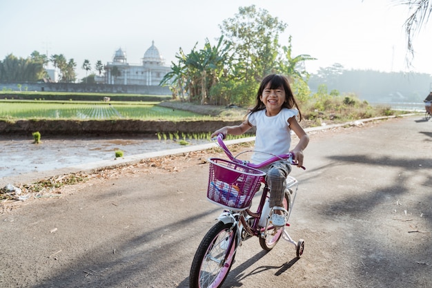 幼児は屋外で彼女の自転車に乗って楽しむ