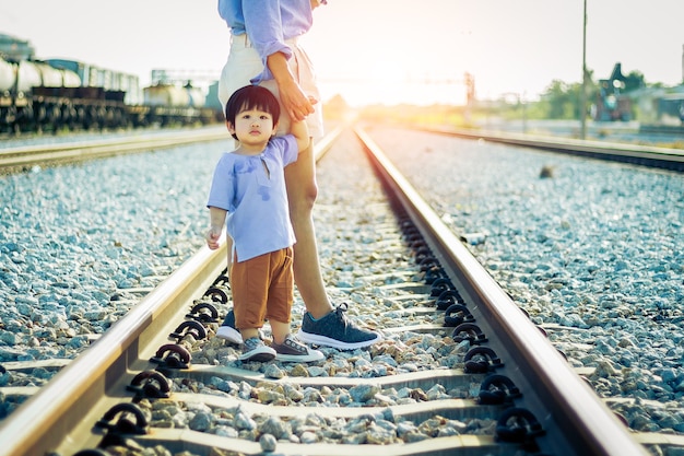 写真 外の彼女の母親と手をつないている幼児の女の子