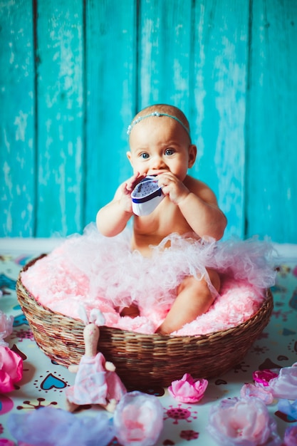 "Toddler girl sitting putting shoe in mouth"