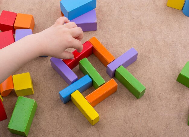 Toddler hand over Colorful building blocks