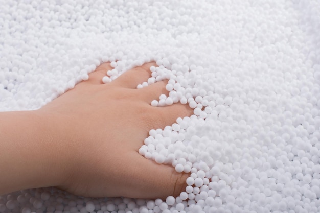 Toddler hand in White polystyrene foam balls