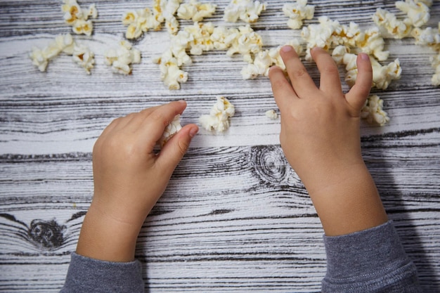 Toddler hands try a popcorn Kid39s curiosity National Popcorn Day concept Top view