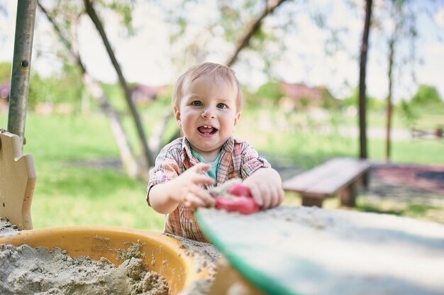 Foto il bambino sta giocando nella sabbiera sul prato verde.