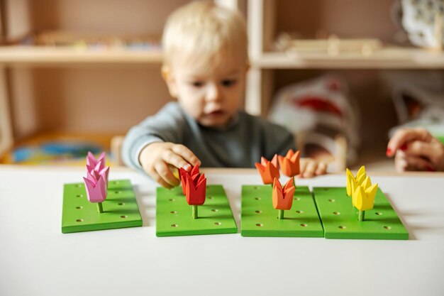 Foto un bambino sta giocando con giocattoli montessori educativi in legno e imparando i colori