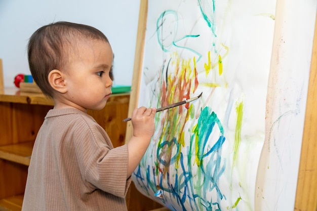 Premium Photo  Toddler painting on a paper canvas