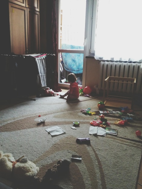 Photo toddler playing with toys in room at home