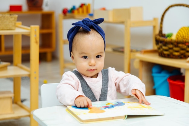 Toddler reading book by the table