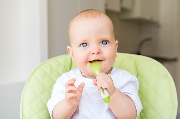 toddler sitting in a high chair and eats