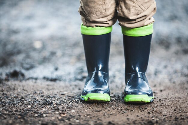 Photo toddler wearing rubber boots in rainy weather