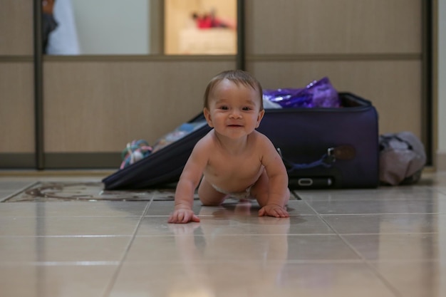 Toddlers portrait in front of the luggage on the floor