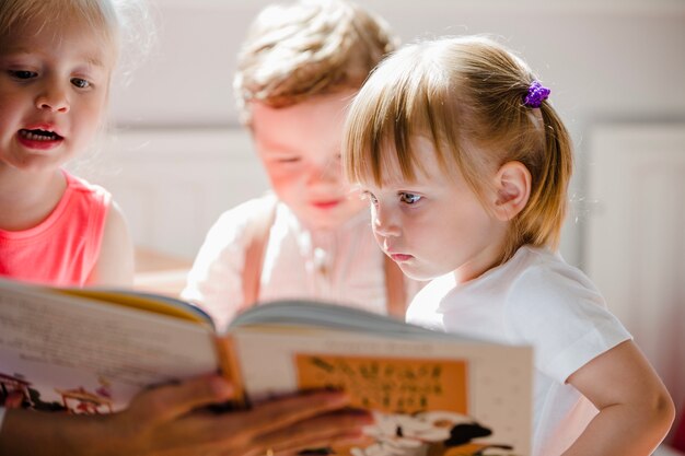 Toddlers reading book in preschool