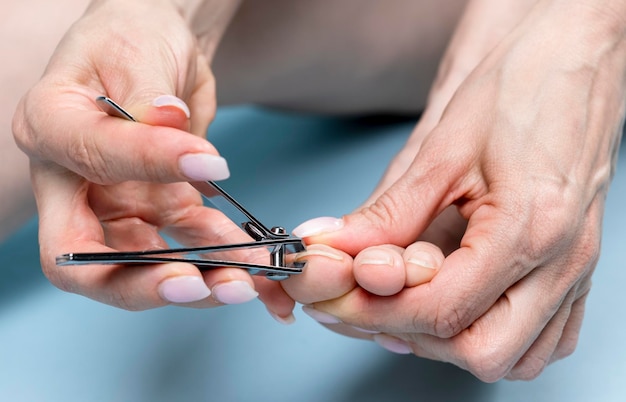 Toe nails cutting with nail clippers, pedicure concept