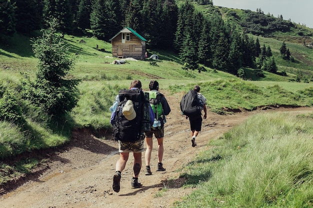 Toerisme bergen levensstijl natuur mensen concept Groep wandelaars met rugzakken lopen langs een pad naar een bergrug Backpackers stijl Concept van actieve vrije tijd