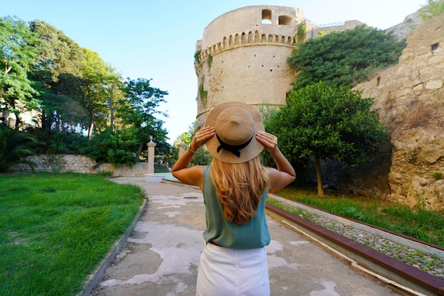 Toerisme in Calabrië Achteraanzicht van mooie vrouw in Crotone met Charles V Aragon Castle in Crotone Calabrië Italië