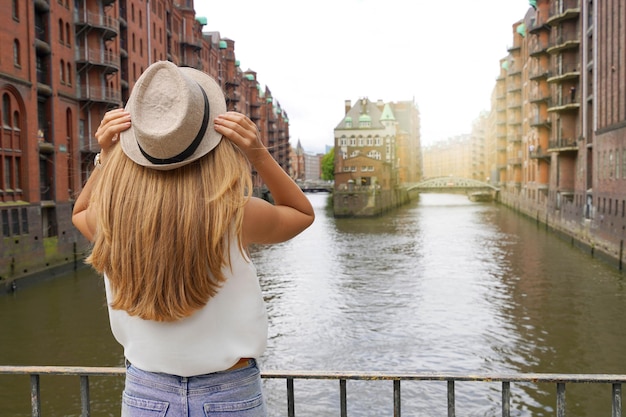 Toerisme in Duitsland Mooie jonge vrouw een bezoek aan de wijk Speicherstadt in de haven van Hamburg Duitsland UNESCO Werelderfgoed